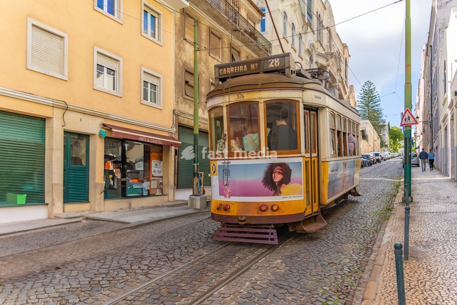 View of vintage yellow No28 tram on a sunny day in the Alfama District, Lisbon, Portugal, Europe