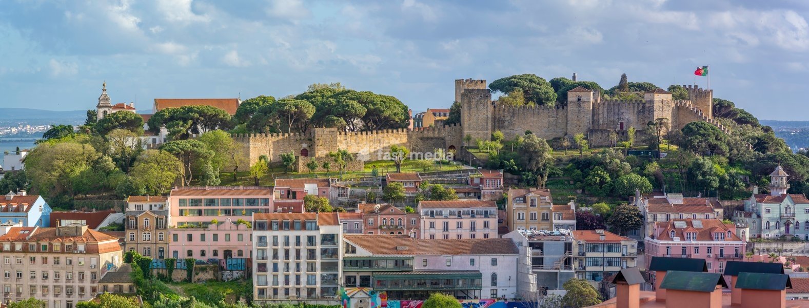 Panoramic view of Lisbon Castle from Miradouro da Senhora do Monte scenic point on a sunny day in the Alfama District, Lisbon, Portugal, Europe