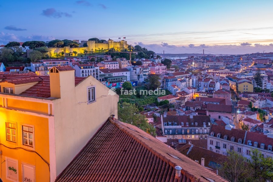 Panoramic view of Lisbon Castle from Miradouro da Senhora do Monte scenic point at dusk in the Alfama District, Lisbon, Portugal, Europe