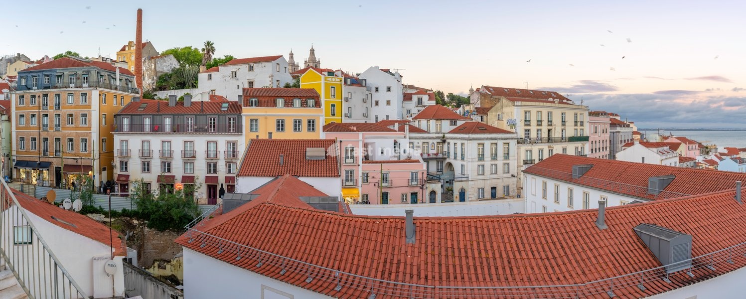 View of colourful buildings and red rooftops at sunset in the Alfama District, Lisbon, Portugal, Europe