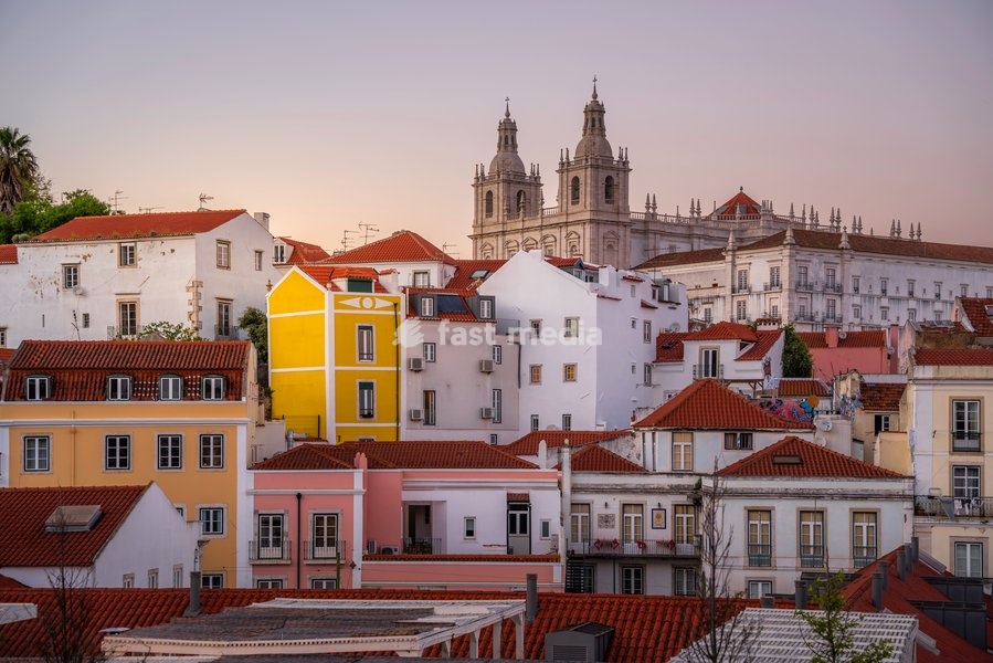 View of colourful buildings and red rooftops at sunset in the Alfama District, Lisbon, Portugal, Europe