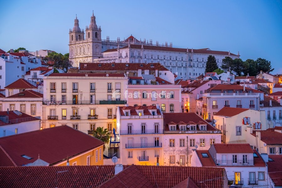 View of colourful buildings and red rooftops at dusk in the Alfama District, Lisbon, Portugal, Europe