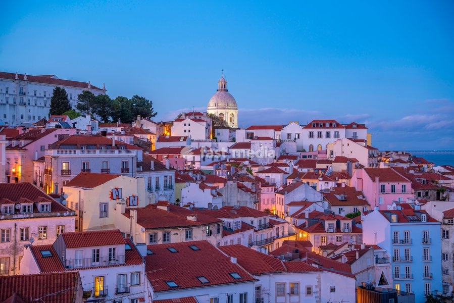 View of colourful buildings and red rooftops at dusk in the Alfama District, Lisbon, Portugal, Europe