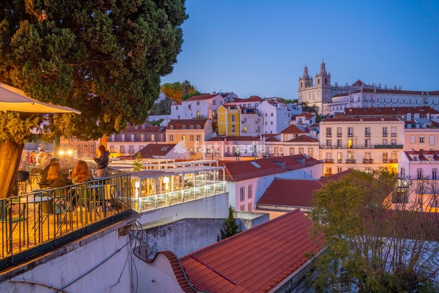 View of colourful buildings and red rooftops at dusk in the Alfama District, Lisbon, Portugal, Europe