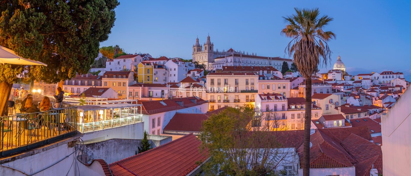 View of colourful buildings and red rooftops at dusk in the Alfama District, Lisbon, Portugal, Europe