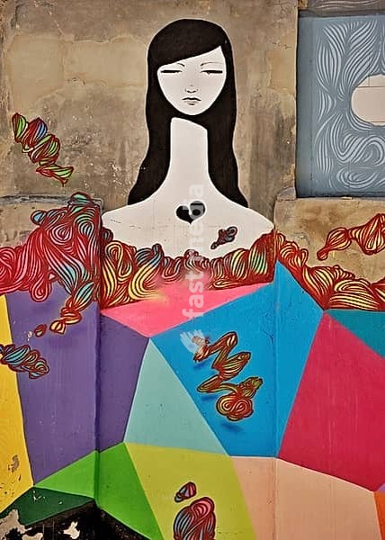 Mural representing a sad woman with a broken heart, surrounded by colorful geometric shapes and organic lines
