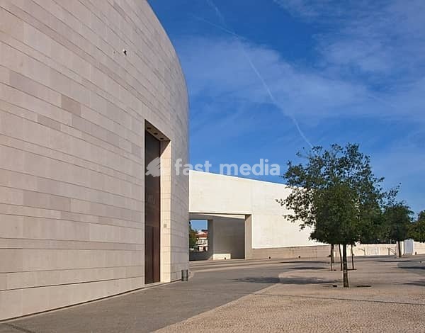 Modern building of Centro Cultural de Belém with trees under blue sky in Lisbon, Portugal, Europe