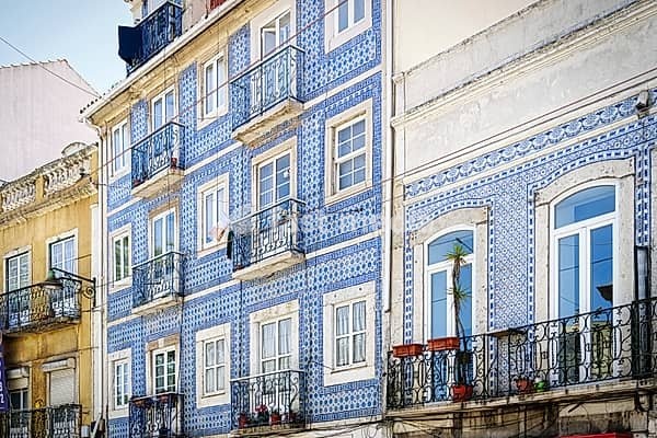 Typical lisbon residential building with the tiled façade and the balconies with the ornate wrought-iron railings