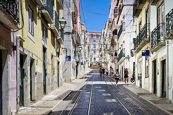 Lisbon, Portugal May 29 2024: view uphill along the narrow street of the funicular Ascensor da Bica funicular in lisbon with strolling tourists