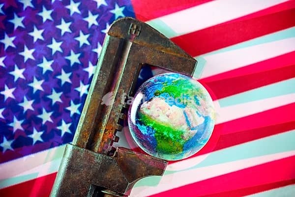 Globe in pincers on USA flag, symbolic photo for the Trump tariffs and global economic consequences