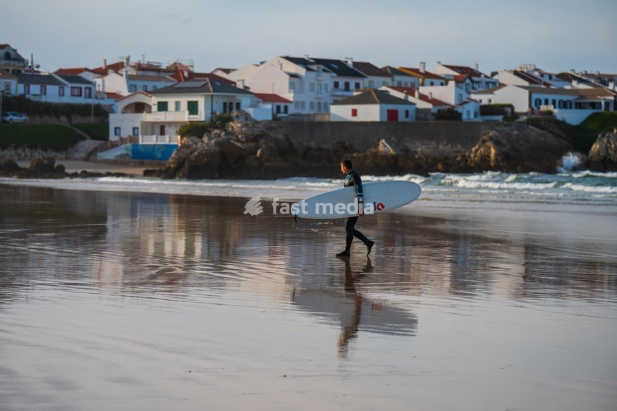 Surfer walking out of the water in Baleal Island beach, Portugal