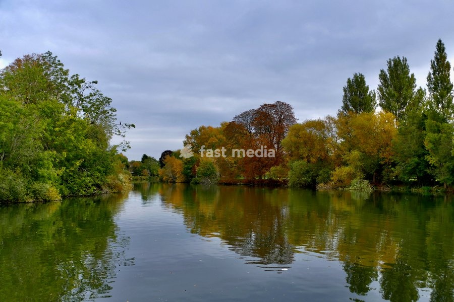 Autumnal colours reflected in The River Thames at Kings Meadow on an overcast afternoon