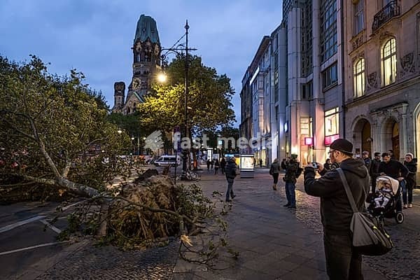 DEU Germany Germany Berlin Fire brigade operation on Kurfürstendamm. Storm Xavier had caused trees to fall onto the street. Passers-by take souvenir photos