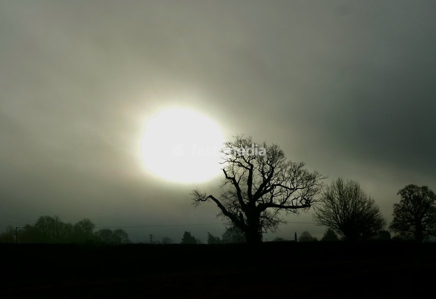 The sun burns through the mornings light mist over the countryside