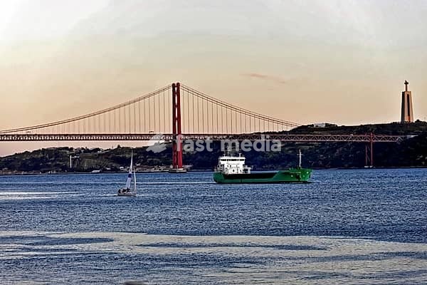Bridge over the Tagus River, Ponte 25 de Abril, inaugurated 1966, suspension bridge, in front boats of a sailing school, Alcantara, Lisbon, Portugal, river landscape with bridge and boats in front of sunset, statue in the background, Lisbon, Portugal