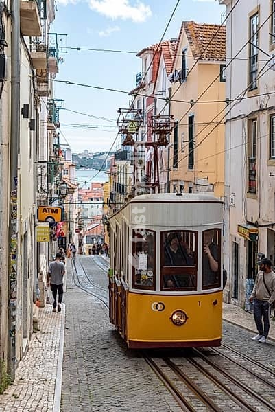 Lisboa, Portugal - June 04, 2024 - Iconic historic Ascensor da Bica in old town Lisboa, Portugal, Tajo river in the background