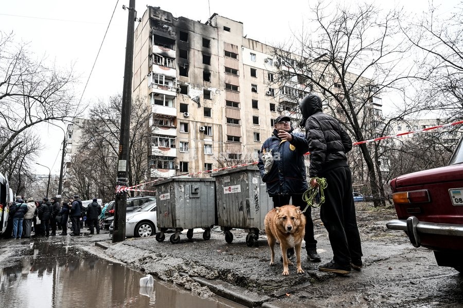 People stand outside a residential multi-storey building damaged as a result of a Russian strike drone hit, Zaporizhzhia, Ukraine, on February 26, 2026. Russian forces launched a massive missile and drone attack on the city. Nine people were injured, and residential buildings, several shopping…