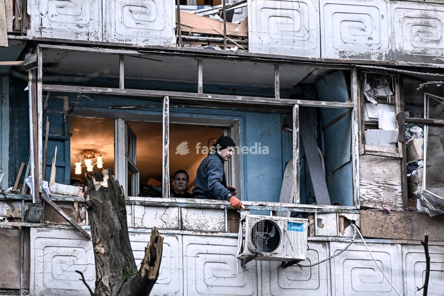 People stand on a balcony of a residential multi-storey building damaged as a result of a Russian strike drone hit, Zaporizhzhia, Ukraine, on February 26, 2026. Russian forces launched a massive missile and drone attack on the city. Nine people were injured, and residential buildings, several…