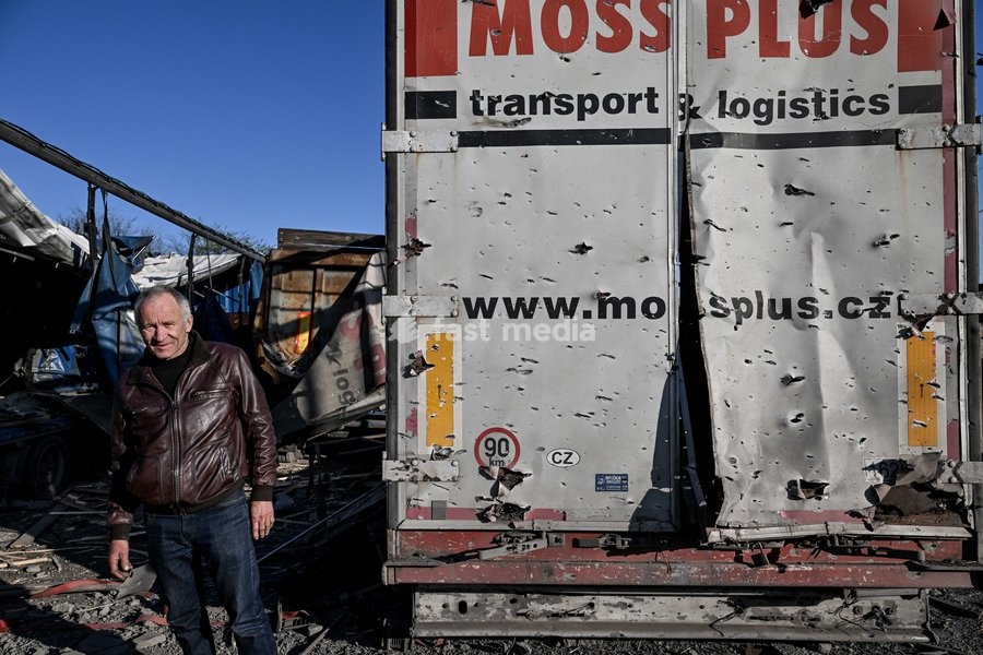 A man stands by a truck damaged by a Russian drone strike at a parking lot in Zaporizhzhia, Ukraine, April 15, 2026. The attack killed a 74-year-old woman and damaged the stop, a parking lot, and nearby residential buildings