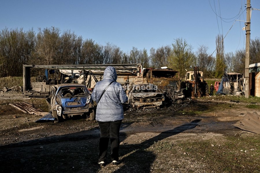 A woman looks at cars destroyed by a Russian drone strike at a parking lot in Zaporizhzhia, Ukraine, April 15, 2026. The attack killed a 74-year-old woman and damaged the stop, a parking lot, and nearby residential buildings