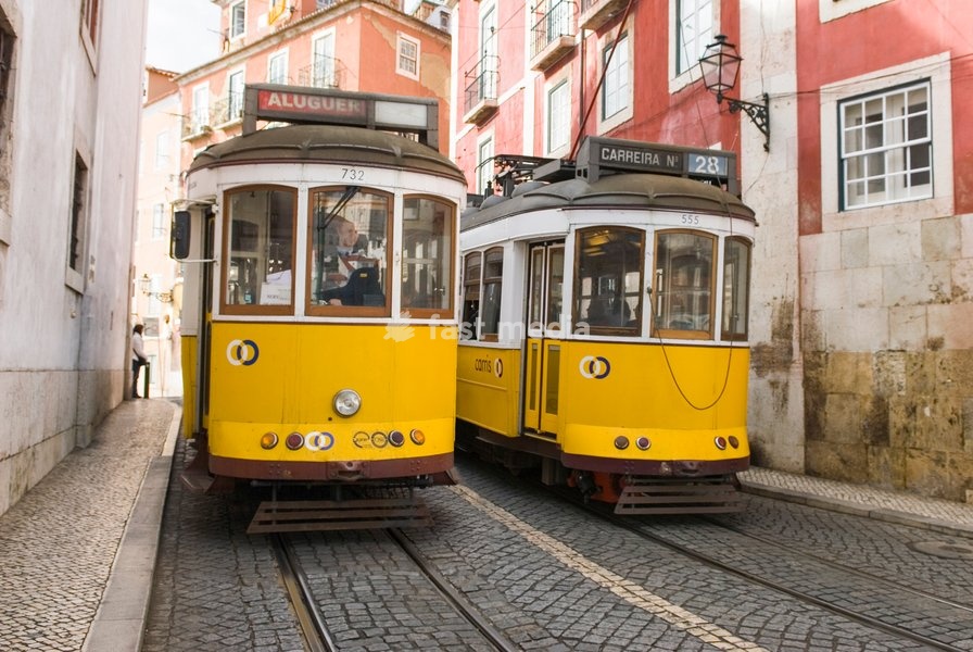 Tramway travels along Limoeiro street in Alfama district of Lisbon, Portugal on a busy day in the city