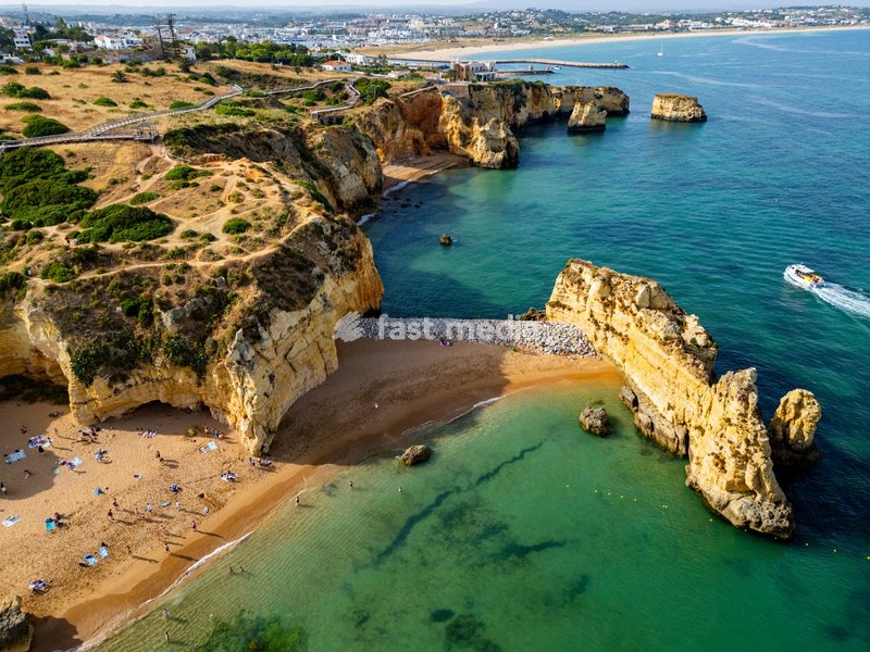 Beach cliffs at sunset with water and sand in Algarve during the evening
