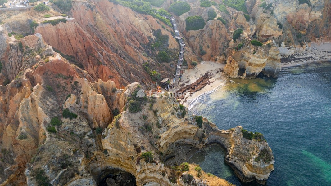 Sunset view of beach cliffs by the sea in Algarve Portugal with rocky formations and calm water