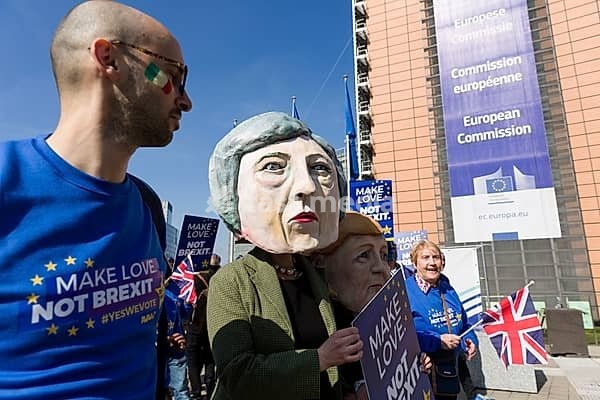 Belgium, Brussels, on March 21, 2019: demonstration in front of the European Commission against Brexit with the slogan Make Love, Not Brexit. Participants wear masks of German Chancellor Angela Merkel and British Prime Minister Theresa May, Berlaymont, Europe, Western Europe, Belgium
