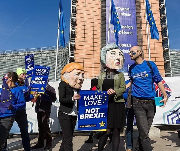 Belgium, Brussels, on March 21, 2019: demonstration in front of the European Commission against Brexit with the slogan Make Love, Not Brexit. Participants wear masks of German Chancellor Angela Merkel and British Prime Minister Theresa May, Berlaymont, Europe, Western Europe, Belgium
