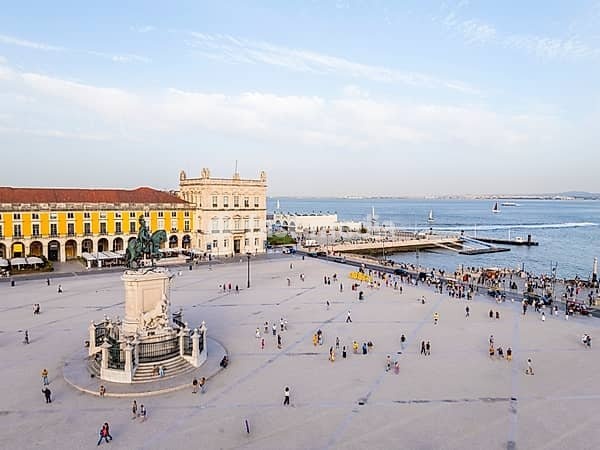 Lisbon City at Sunset. Commerce Plaza, Equestrian Statue, Tourists and Tejo River. Portugal. Aerial Drone Shot