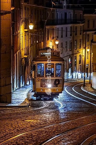 Historische Strassenbahn bei Nacht in einer Strasse in Lissabon, Portugal. Historical Tram of the famous line 28 at night in the narrow alleys of the old town of Lisbon, Portugal