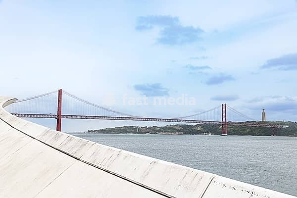 Ponte 25 de Abril und MAAT, Museu de Arte, Arquitetura e Tecnologia am Ufer des Tejo in Lissabon, Portugal. MAAT, Museu de Arte, Arquitetura e Tecnologia, at the bank of the river Tejo in Lisbon, Portugal