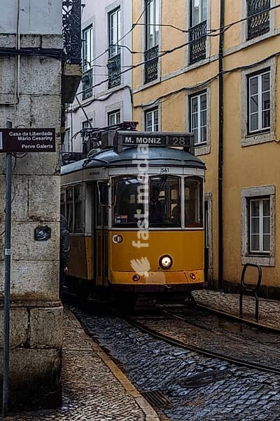 Historische Strassenbahn an einem regnerischen Frühlingstag in der Altstadt von Lissabon, Portugal. Historical Tram of the famous line 28 on a rainy day in the narrow alleys of the old town of Lisbon, Portugal