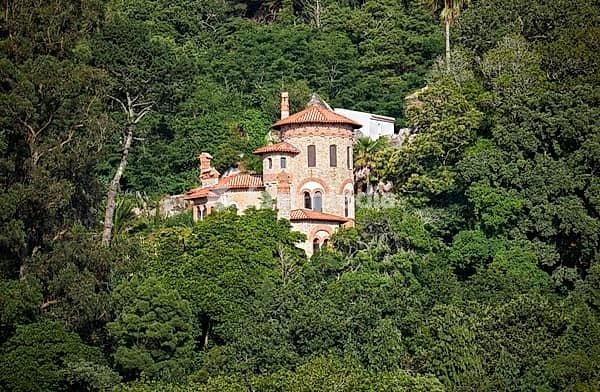 The romantic view of Villa Sassetti hidden in the rich vegetation of wooded hills. Sintra, Portugal