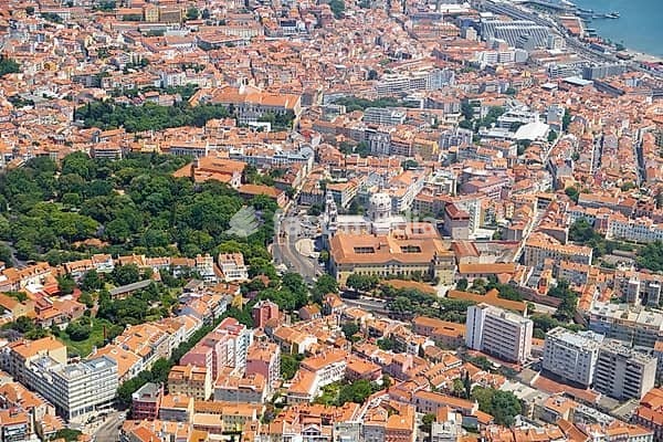 The plane is landing over the Estrela Basilica (Basilica da Estrela) and Estrela Garden (Jardim da Estrela) in the historic part of Lisbon. Portugal