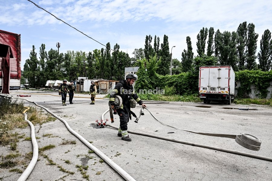 A firefighter unrolls a fire hose at a parking lot, where a fire broke out due to Russian drone strikes, Zaporizhzhia, Ukraine, June 25, 2026. The Russian army attacked the city with strike drones, targeting a petrol station, Ukrzaliznytsia (Ukrainian Railways) locomotives and a parking lot. Fires…