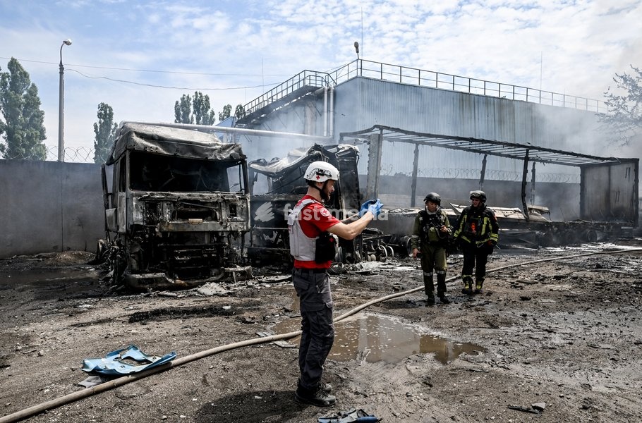 Rescuers and a paramedic work at a parking lot, where a fire broke out due to Russian drone strikes, Zaporizhzhia, Ukraine, June 25, 2026. The Russian army attacked the city with strike drones, targeting a petrol station, Ukrzaliznytsia (Ukrainian Railways) locomotives and a parking lot. Fires…