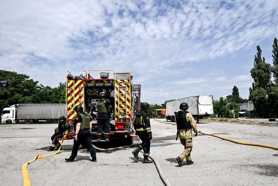 Firefighters stay by a fire engine at a parking lot, where a fire broke out due to Russian drone strikes, Zaporizhzhia, Ukraine, June 25, 2026. The Russian army attacked the city with strike drones, targeting a petrol station, Ukrzaliznytsia (Ukrainian Railways) locomotives and a parking lot. Fires…
