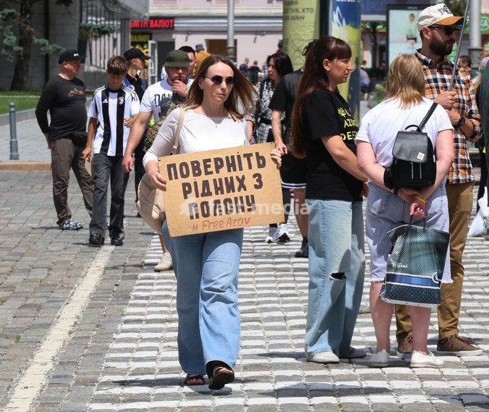 A woman carries a placard reading "Bring Relatives Back from Captivity" along a zebra crossing during the “Don’t Stay Silent! Captivity Kills!” rally in Kharkiv, Ukraine, July 12, 2026. In the northeastern Ukrainian city, families of Ukrainian prisoners of war and missing military personnel took…
