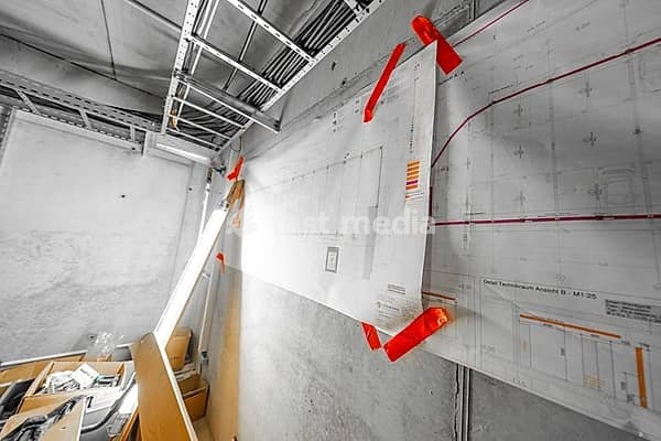 Construction drawings hang on a concrete wall, secured with red adhesive tape, parking garage construction, Calw, Germany
