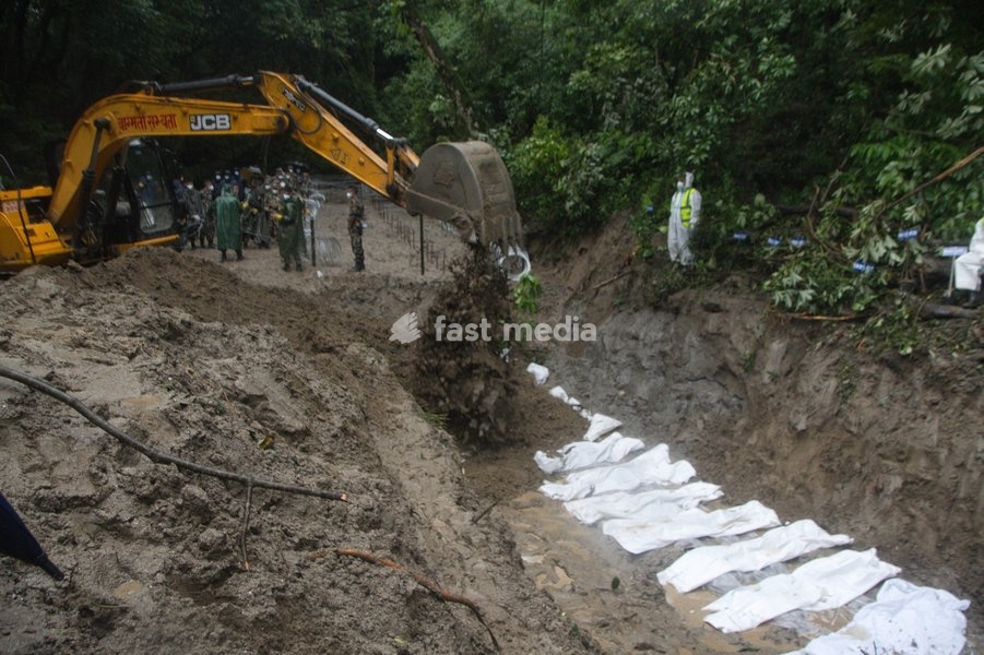 Rescue workers and officials manage a mass burial trench for unidentified remains recovered after severe flash floods in Gokarna, Kathmandu, Nepal, Tuesday, Sept. 1, 2026. Authorities initiated temporary burials as morgue capacities reached limits following the disaster