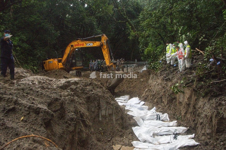 Rescue workers and officials manage a mass burial trench for unidentified remains recovered after severe flash floods in Gokarna, Kathmandu, Nepal, Tuesday, Sept. 1, 2026. Authorities initiated temporary burials as morgue capacities reached limits following the disaster