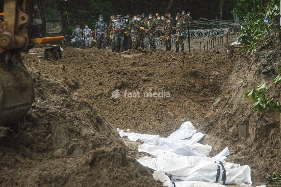 Rescue workers and officials manage a mass burial trench for unidentified remains recovered after severe flash floods in Gokarna, Kathmandu, Nepal, Tuesday, Sept. 1, 2026. Authorities initiated temporary burials as morgue capacities reached limits following the disaster