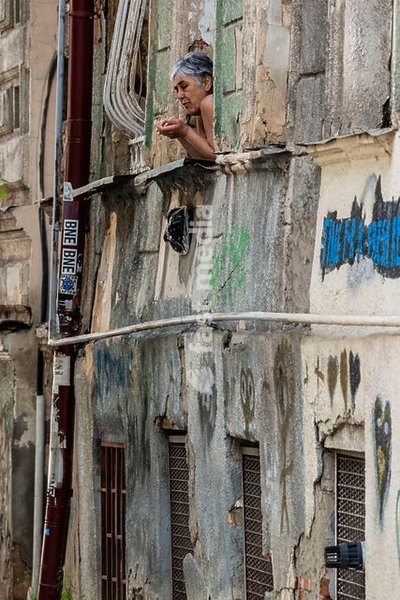 woman on a balcony observing a dilapidated street, Tbilisi, Georgia, Asia