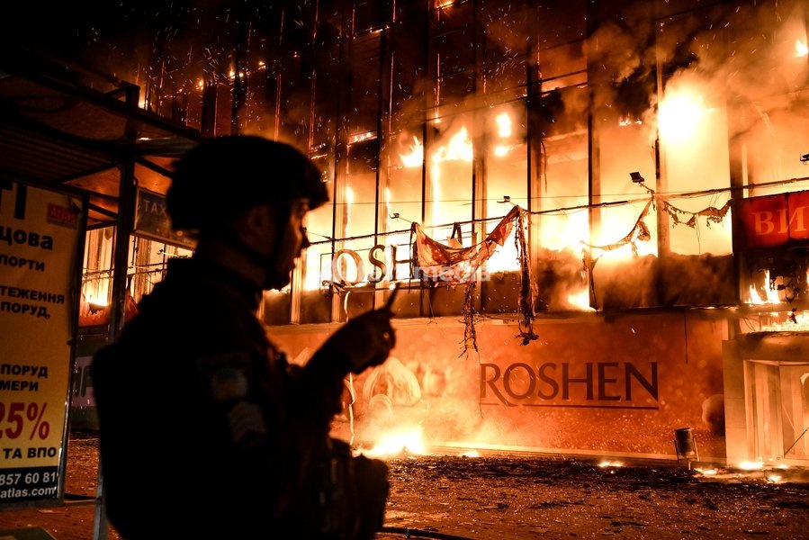 A law enforcer stands in front of the burning Intrade shopping centre that caught fire due to an overnight Russian drone attack, Zaporizhzhia, Ukraine, September 21, 2026. On Monday night, Russian forces struck the southeastern city with strike UAVs and an FPV drone. The attack destroyed the…