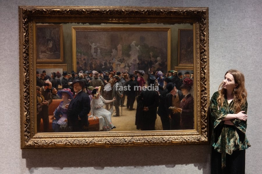 A staff member views 'Au Salon des Artistes Français en 1911' by Henri Adolphe Laissement (est. £100k - £150k) which is to go on auction at Bonhams' 19th Century and British Impressionist Art Sale on 23rd September 2026 at Bonhams in London, England, UK on Monday 21 September, 2026