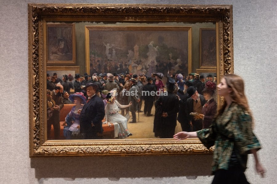 A staff member views 'Au Salon des Artistes Français en 1911' by Henri Adolphe Laissement (est. £100k - £150k) which is to go on auction at Bonhams' 19th Century and British Impressionist Art Sale on 23rd September 2026 at Bonhams in London, England, UK on Monday 21 September, 2026