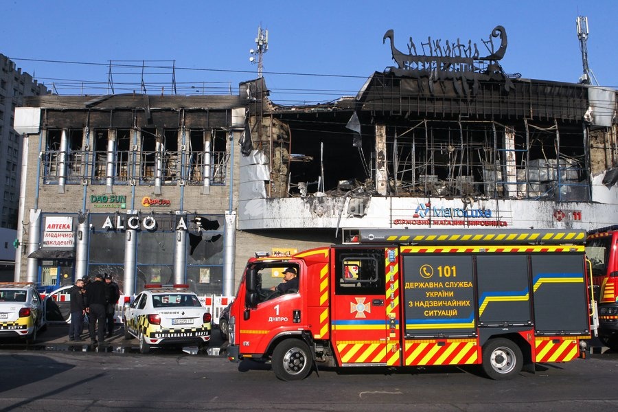 Police cars and a fire engine are parked outside the New Continent shopping centre, which shows extensive damage after being set ablaze by a targeted Russian jet-drone strike on Saturday evening, September 19, 2026, Dnipro, Ukraine, September 20, 2026