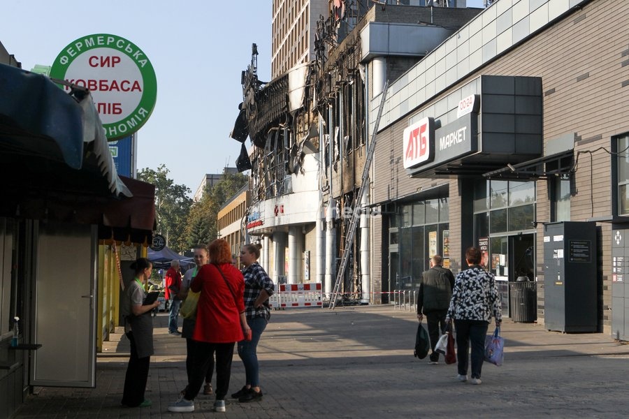 People talk in the street outside the New Continent shopping centre, which shows extensive damage after being set ablaze by a targeted Russian jet-drone strike on Saturday evening, September 19, 2026, Dnipro, Ukraine, September 20, 2026
