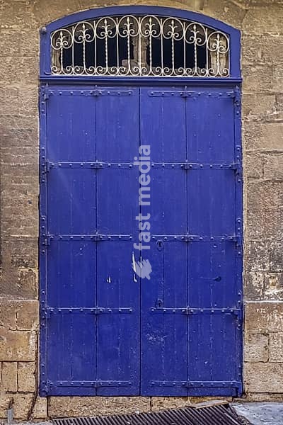 An old wooden blue door in a Mediterranean setting in a historic town in Italien